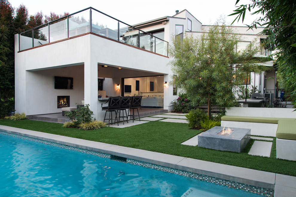 Inspiration for a large contemporary backyard concrete paver patio remodel in Los Angeles with a roof extension