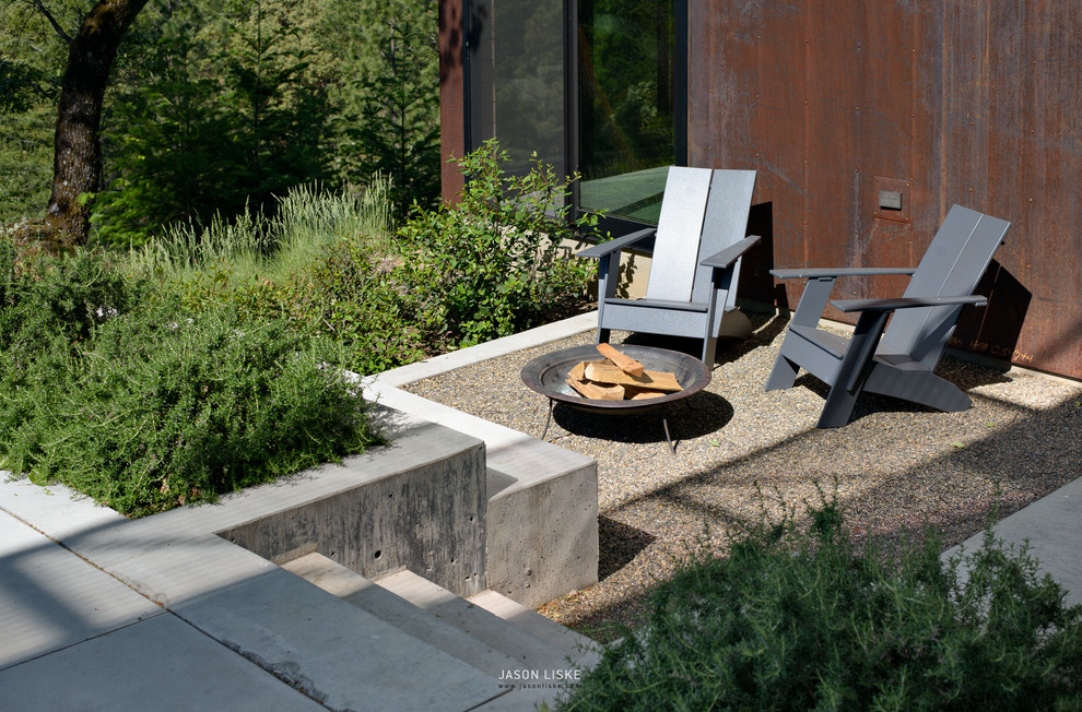 Стильный дизайн: маленький двор в современном стиле с местом для костра и покрытием из гравия для на участке и в саду - последний тренд