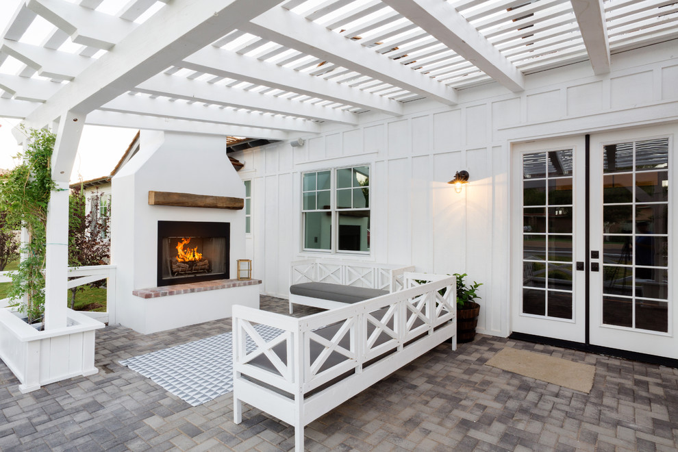 Example of a cottage concrete paver patio design in Phoenix with a fireplace