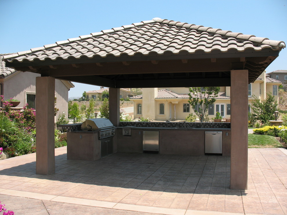 Inspiration pour une grande terrasse arrière méditerranéenne avec une cuisine d'été, du béton estampé et une pergola.