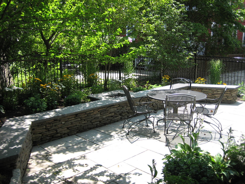 Small classic back patio in Boston with natural stone paving.
