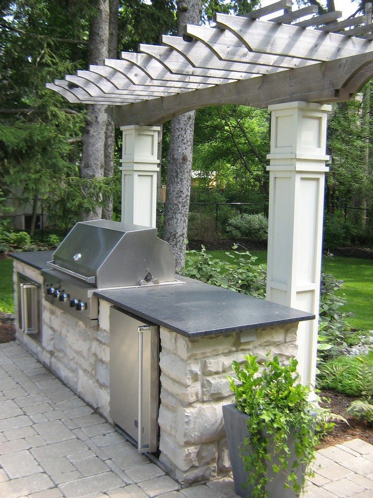 Patio kitchen - large modern backyard concrete paver patio kitchen idea in Toronto with a pergola