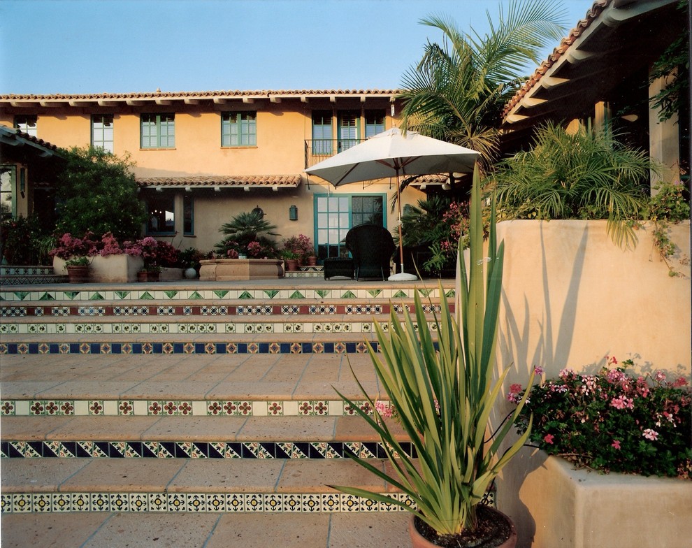 Diseño de patio mediterráneo extra grande en patio trasero con fuente, adoquines de piedra natural y cenador