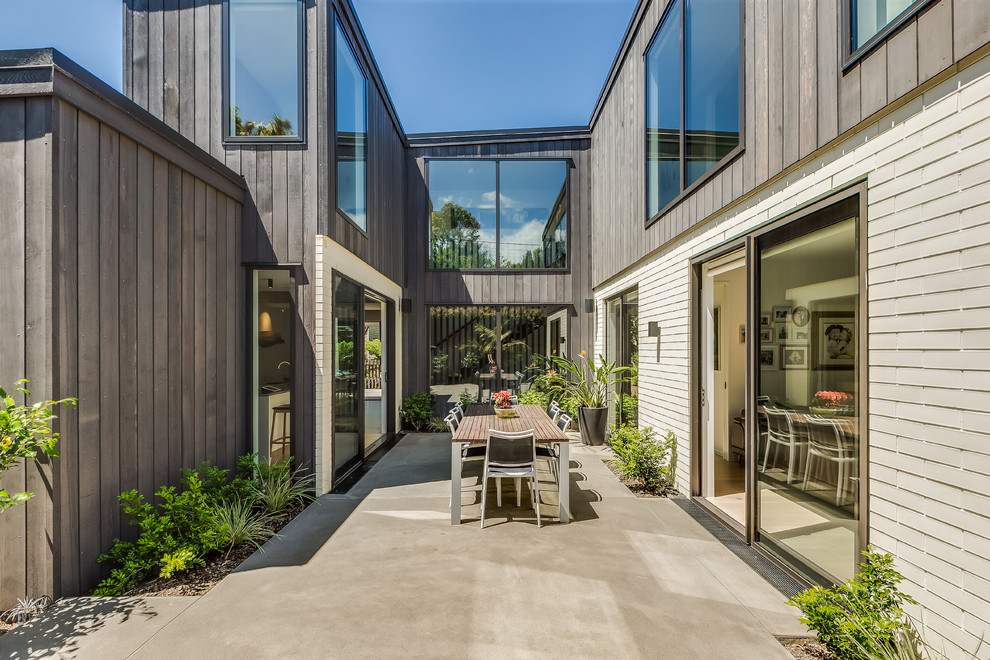 This is an example of a contemporary courtyard patio in Other with concrete slabs and no cover.