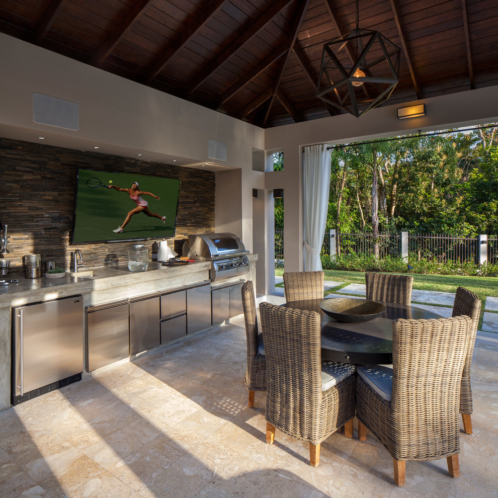 Imagen de patio tropical grande en patio trasero con cocina exterior, cenador y adoquines de piedra natural