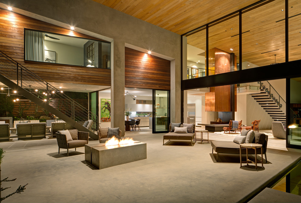 Inspiration for a contemporary back patio in San Diego with a fire feature, concrete slabs and a roof extension.