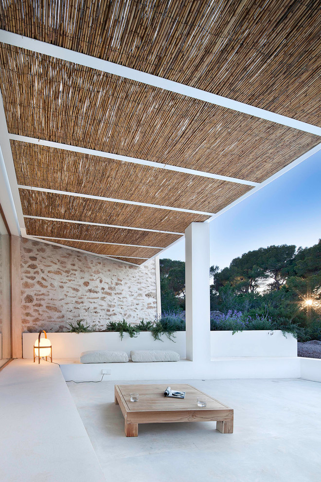 Idee per un grande patio o portico mediterraneo dietro casa con lastre di cemento e un gazebo o capanno