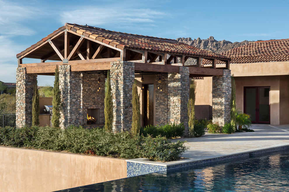 Idée de décoration pour une très grande terrasse arrière méditerranéenne avec une cuisine d'été, des pavés en pierre naturelle et une pergola.