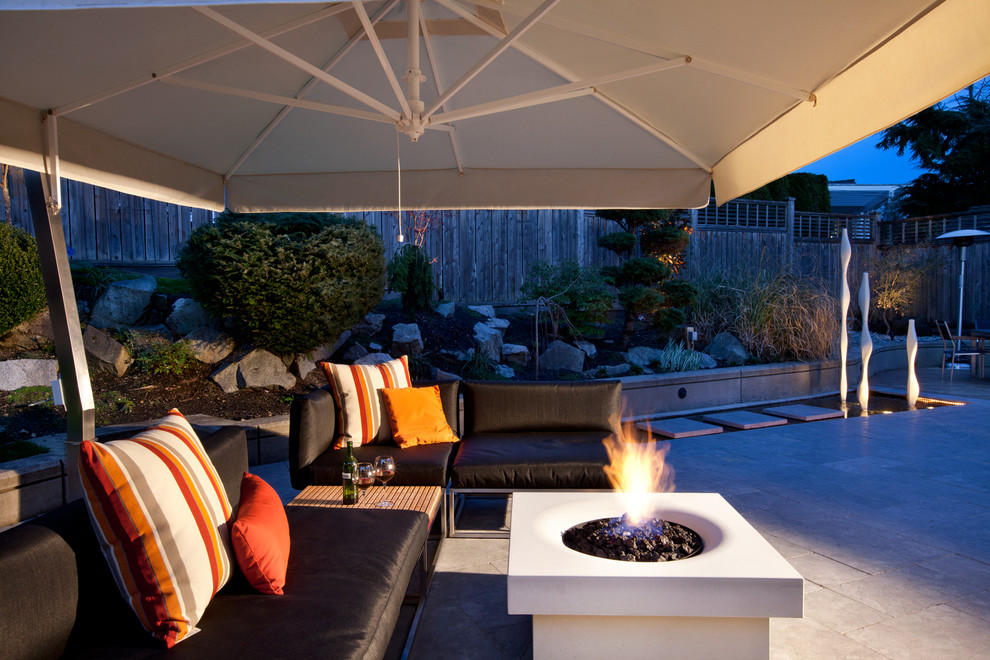 Idee per un patio o portico minimalista di medie dimensioni e dietro casa con pedane e un parasole