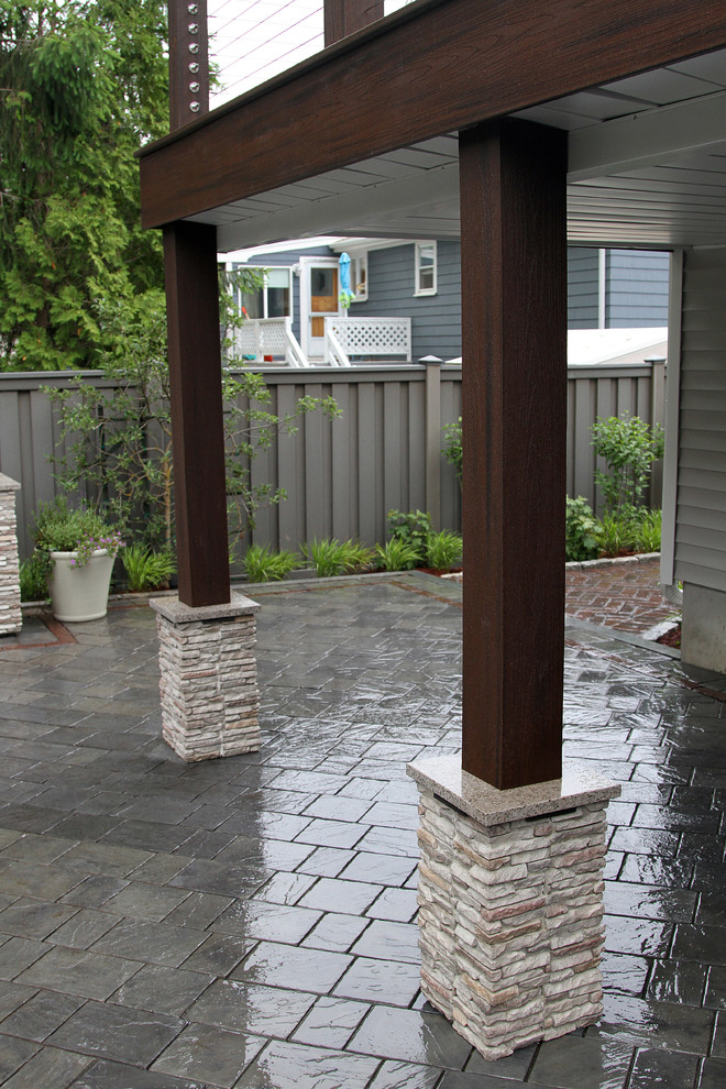 Foto di un patio o portico classico di medie dimensioni e dietro casa con pavimentazioni in cemento e un tetto a sbalzo