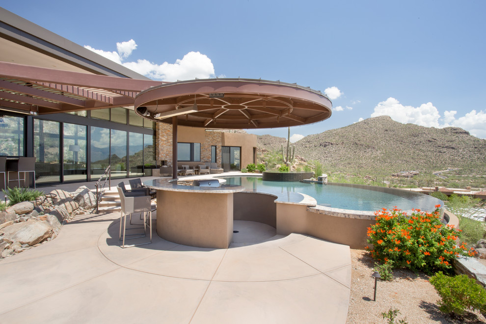 Cette image montre une grande terrasse arrière design avec une cuisine d'été et une pergola.