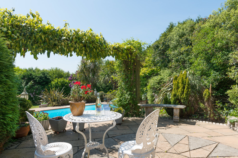 Idee per un patio o portico chic dietro casa con pavimentazioni in pietra naturale e nessuna copertura