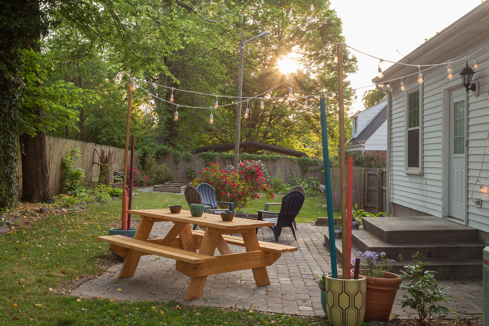 Modelo de patio tradicional renovado de tamaño medio sin cubierta en patio trasero con brasero y adoquines de ladrillo