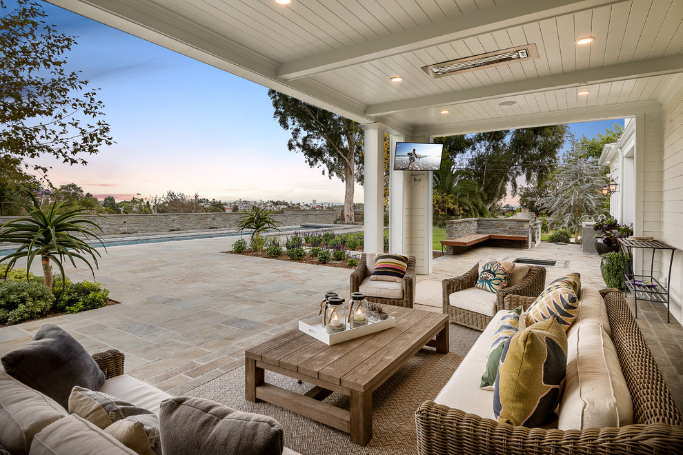 Design ideas for a beach style back patio in Los Angeles with tiled flooring and a roof extension.
