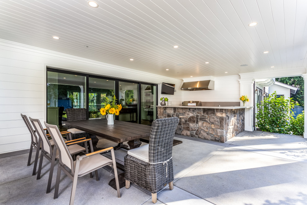 Идея дизайна: большой двор на заднем дворе в стиле неоклассика (современная классика) с летней кухней, покрытием из бетонных плит и навесом
