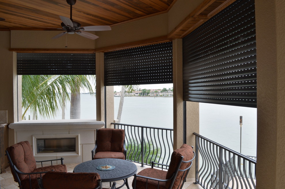 Photo of a medium sized contemporary back patio in Miami with a fire feature, tiled flooring and a roof extension.