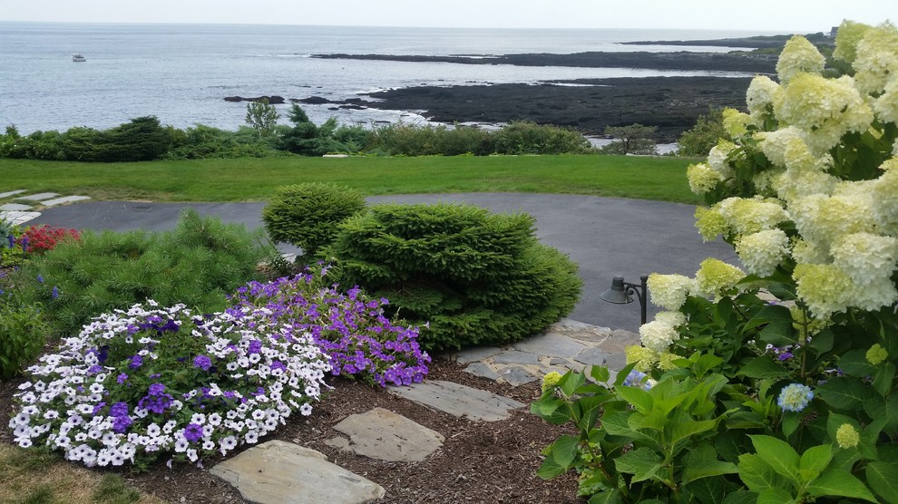 Immagine di un giardino costiero di medie dimensioni con pavimentazioni in pietra naturale