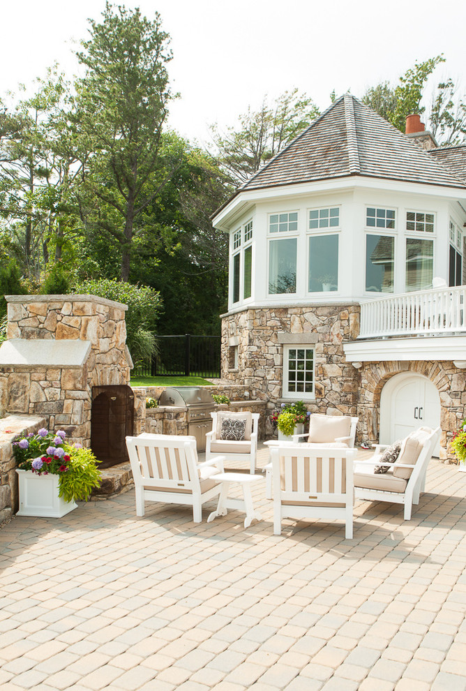 Foto di un patio o portico stile marinaro dietro casa con un focolare, pavimentazioni in cemento e nessuna copertura