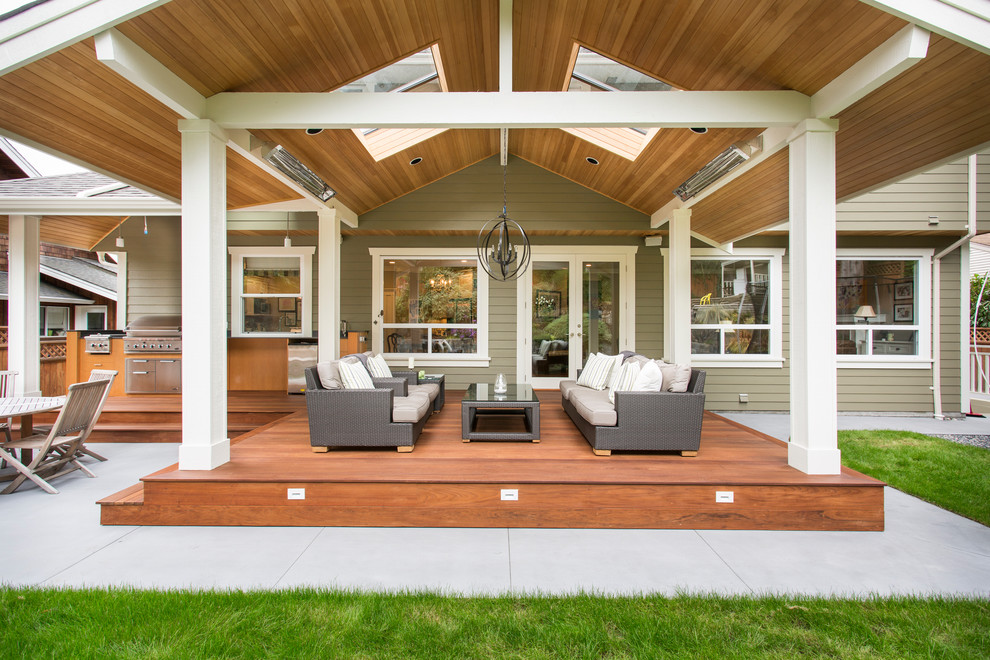 Idée de décoration pour une grande terrasse arrière tradition avec une cuisine d'été et une extension de toiture.
