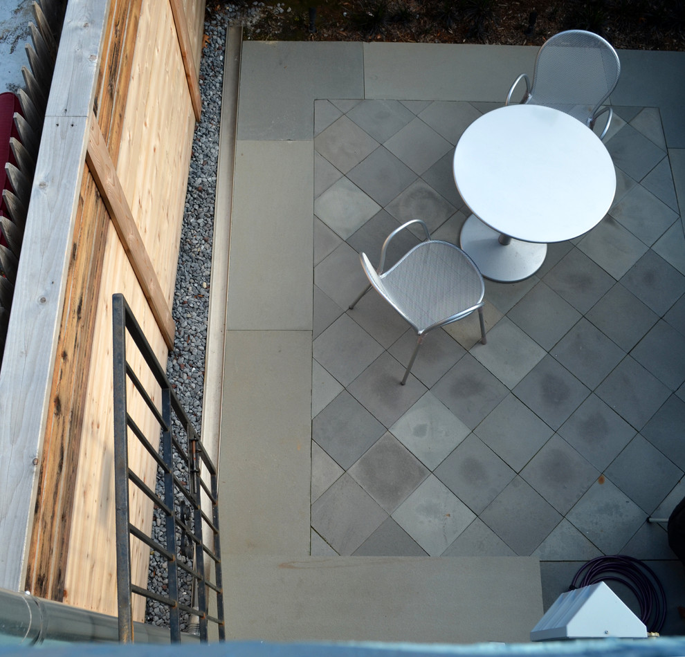 This is an example of a contemporary patio in DC Metro with natural stone paving.