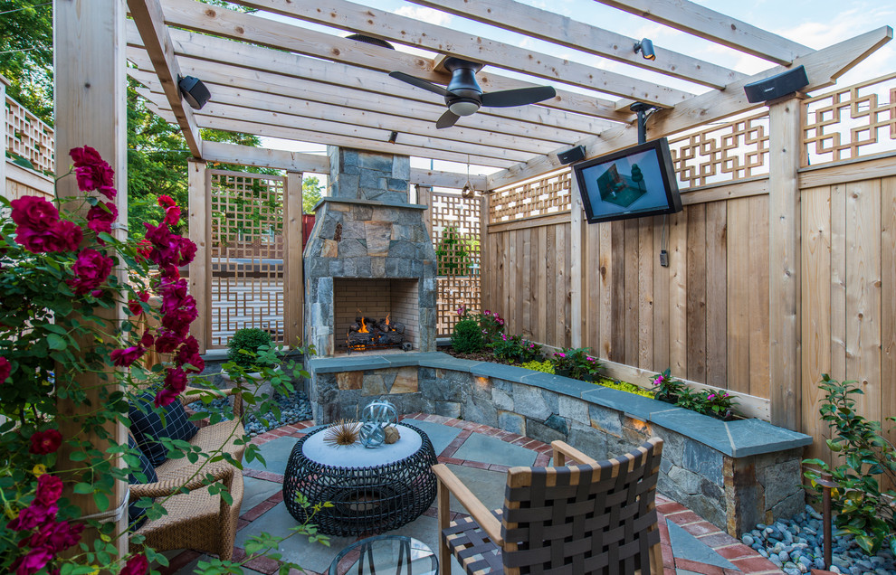Diseño de patio tradicional con adoquines de hormigón, pérgola y chimenea