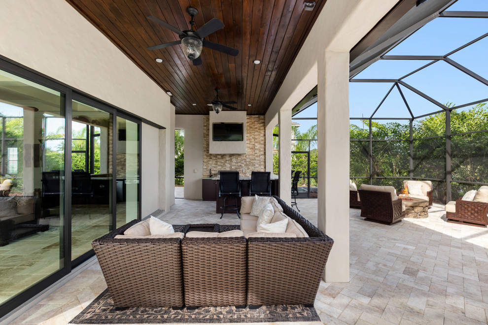 Geräumiger Mediterraner Patio hinter dem Haus mit Outdoor-Küche und Natursteinplatten in Orlando