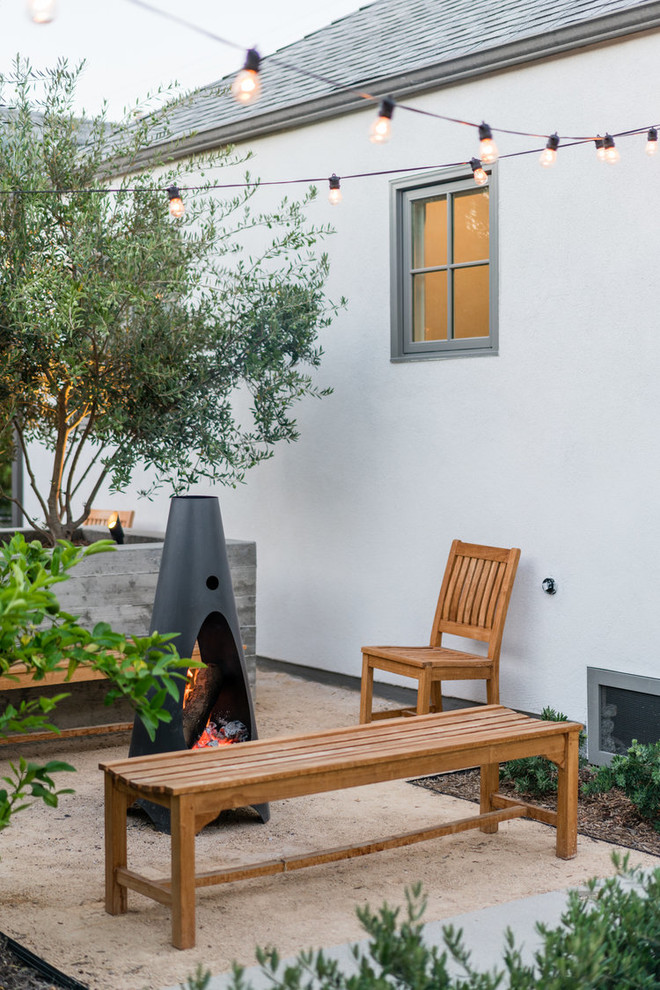 Mittelgroßer, Unbedeckter Moderner Patio hinter dem Haus mit Feuerstelle und Granitsplitt in Los Angeles