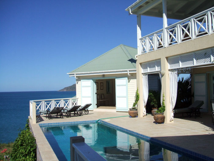 Immagine di un patio o portico stile marinaro di medie dimensioni e dietro casa con piastrelle e un tetto a sbalzo