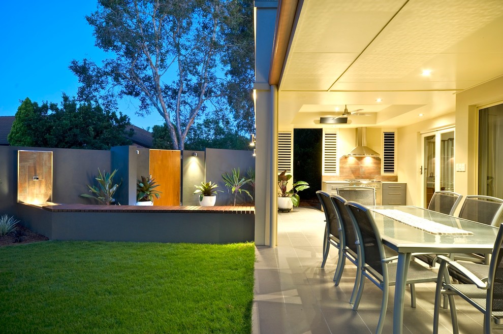 Aménagement d'une grande terrasse arrière contemporaine avec une cuisine d'été et du carrelage.