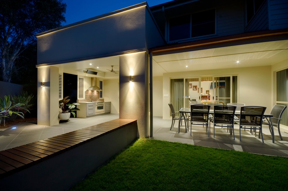 Cette photo montre une grande terrasse arrière tendance avec une cuisine d'été et du carrelage.