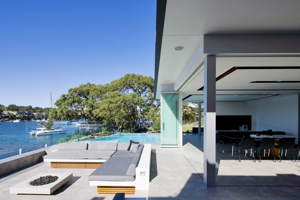 Пример оригинального дизайна: двор в современном стиле с местом для костра без защиты от солнца