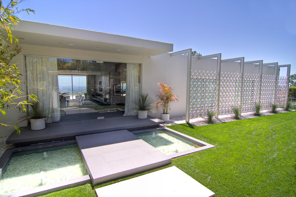 Large modern back patio in Los Angeles with a water feature and no cover.