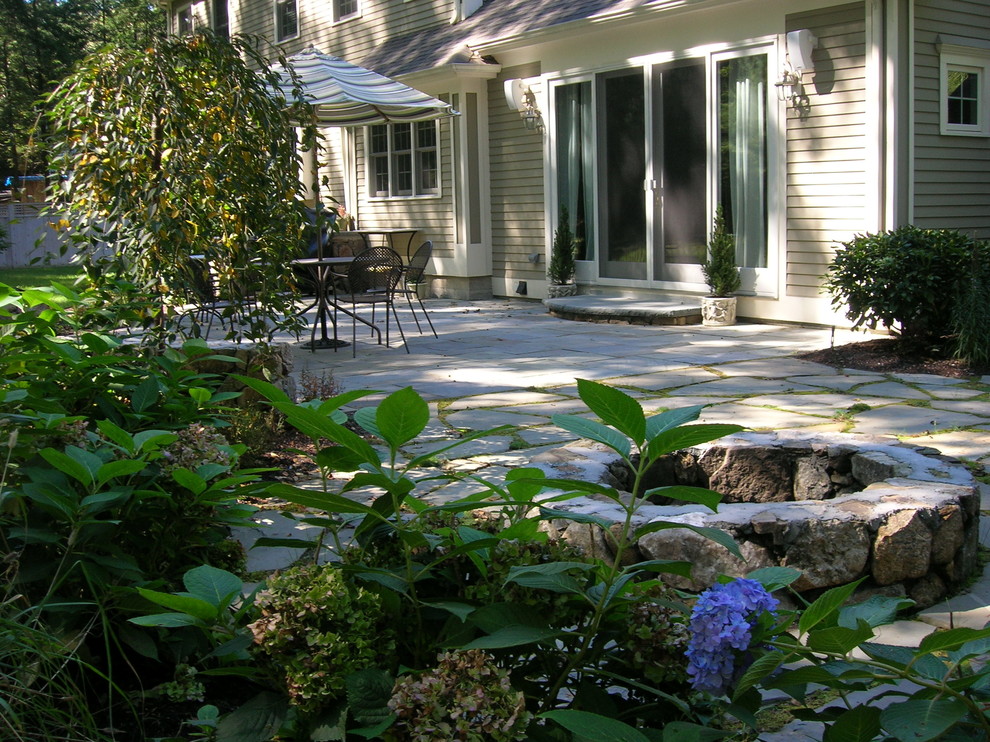Idee per un piccolo patio o portico classico dietro casa con un focolare, pavimentazioni in pietra naturale e nessuna copertura