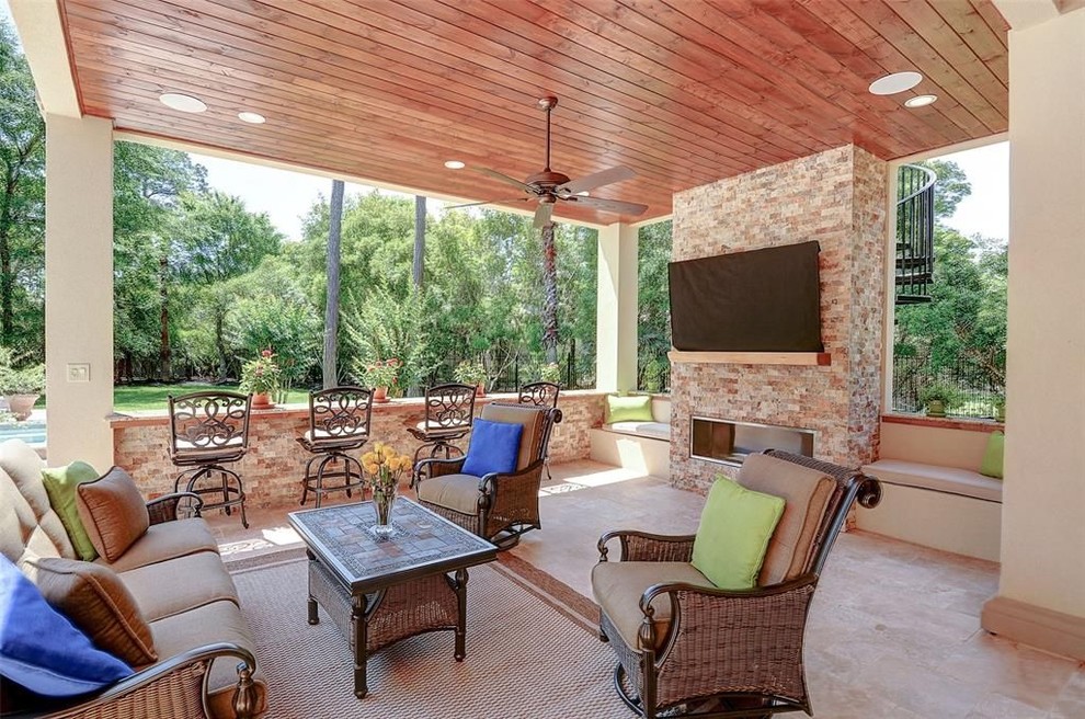 Large contemporary back patio in Houston with an outdoor kitchen, natural stone paving and a roof extension.