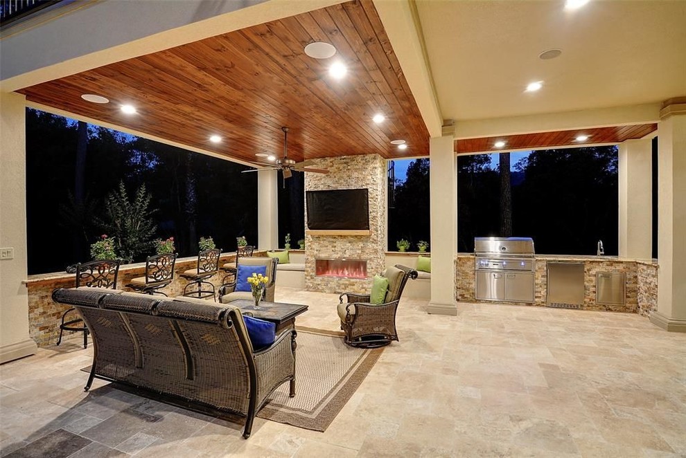 Inspiration pour une grande terrasse arrière design avec une cuisine d'été, des pavés en pierre naturelle et une extension de toiture.