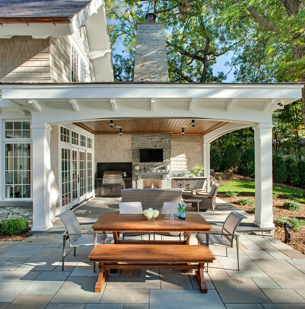 Inspiration for a timeless backyard stone patio remodel in Minneapolis with a roof extension