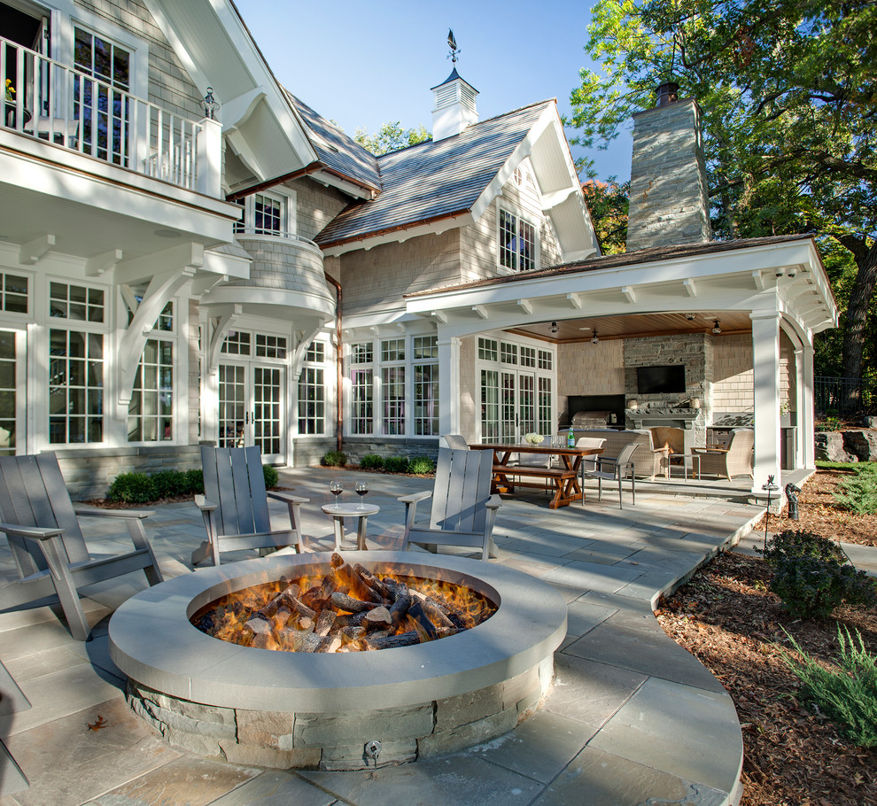Immagine di un patio o portico classico dietro casa con pavimentazioni in pietra naturale e un tetto a sbalzo