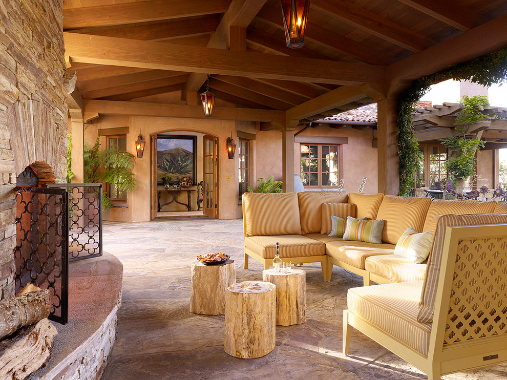 На фото: двор в средиземноморском стиле с местом для костра, покрытием из каменной брусчатки и навесом