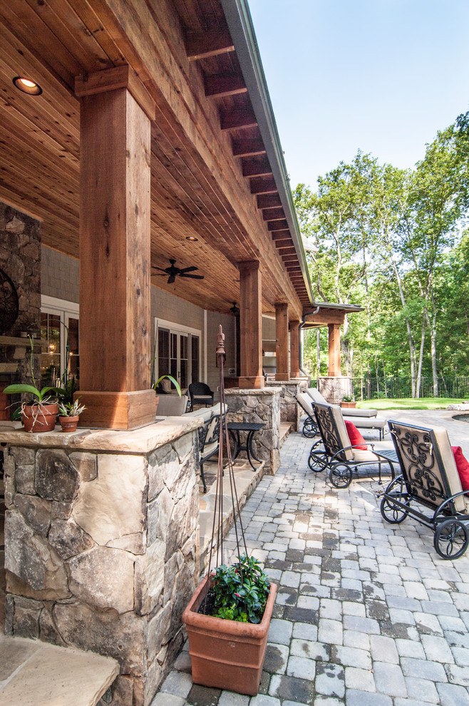 На фото: большой двор на заднем дворе в стиле кантри с летней кухней, навесом и покрытием из каменной брусчатки с