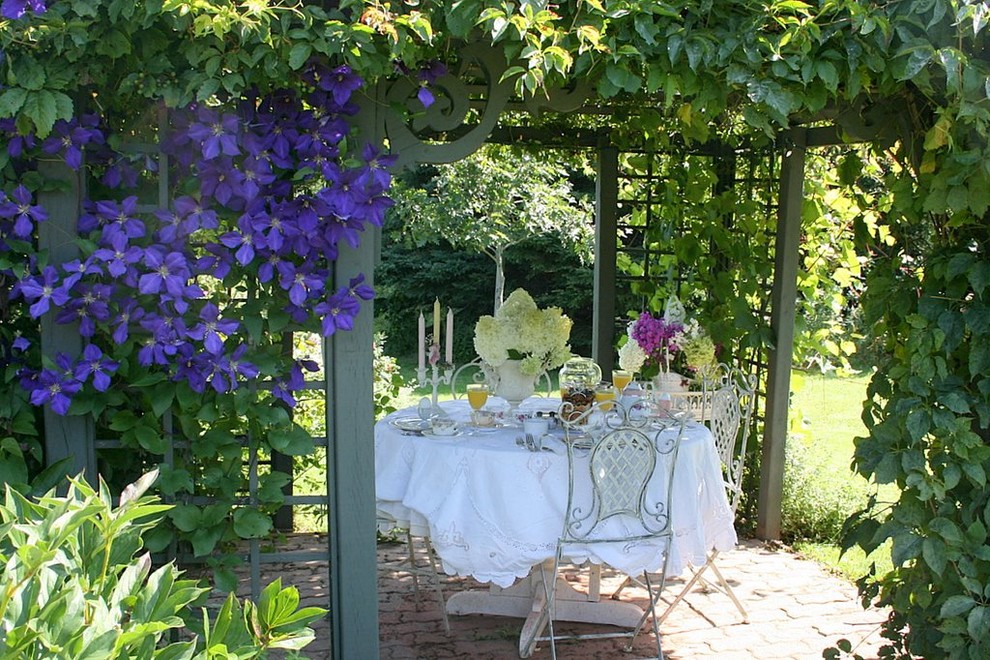 Foto di un patio o portico chic con una pergola