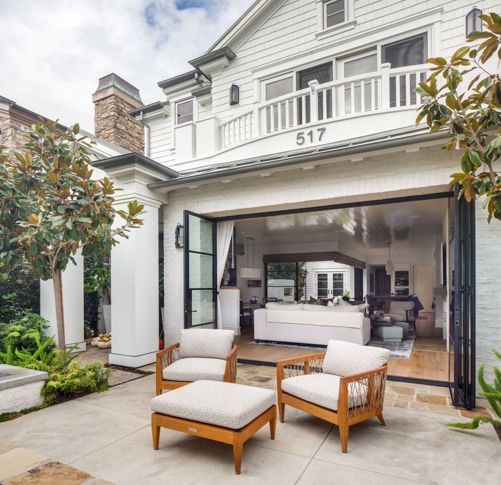 Idée de décoration pour une terrasse arrière design de taille moyenne avec aucune couverture, un foyer extérieur et des pavés en béton.