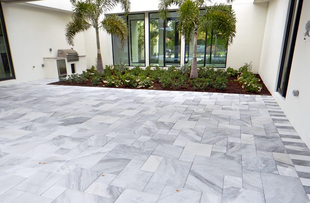 Inspiration for a large modern back patio in Tampa with natural stone paving, no cover and an outdoor kitchen.