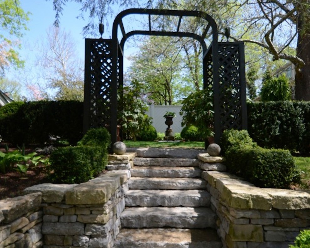 Imagen de jardín tradicional grande en patio trasero con adoquines de piedra natural