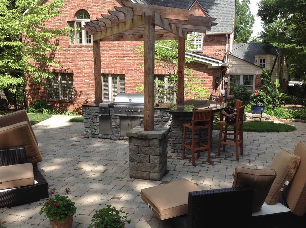 Diseño de patio tradicional de tamaño medio en patio trasero con cocina exterior, adoquines de hormigón y pérgola