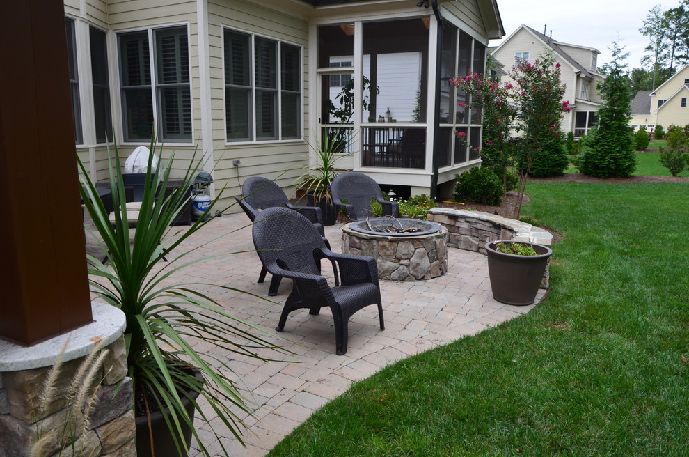 This is an example of a medium sized traditional back patio in Raleigh with a fire feature, concrete paving and a gazebo.