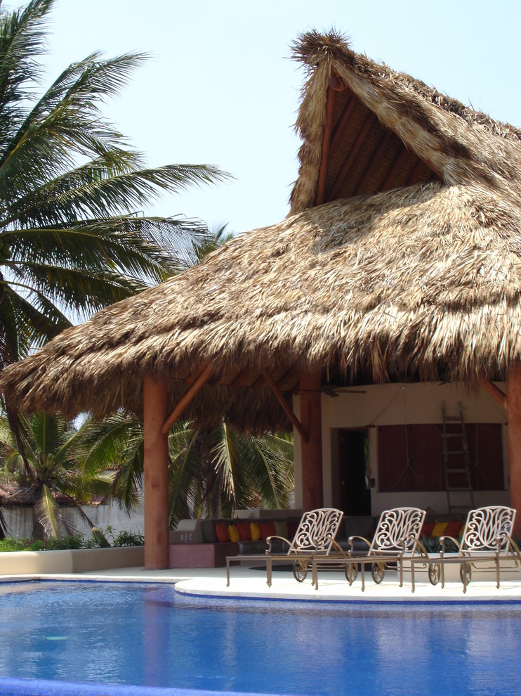 Immagine di un patio o portico tropicale con un tetto a sbalzo