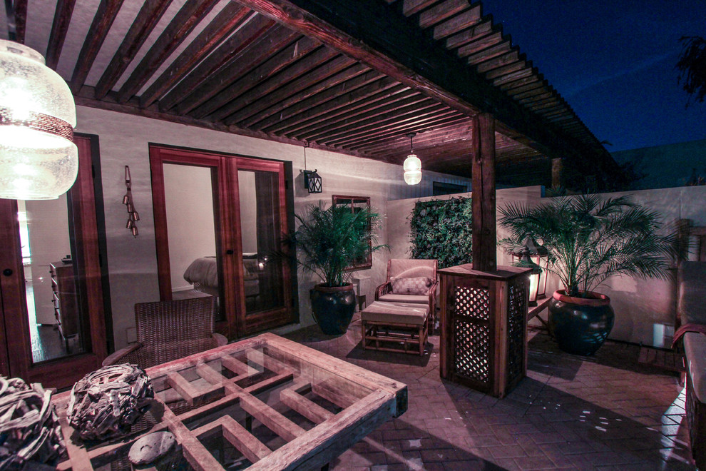 Réalisation d'un mur végétal de terrasse bohème de taille moyenne avec une cour, des pavés en brique et une extension de toiture.