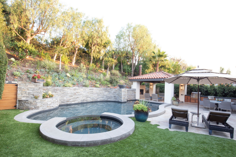 Foto de patio moderno en patio trasero con cocina exterior, adoquines de piedra natural y pérgola