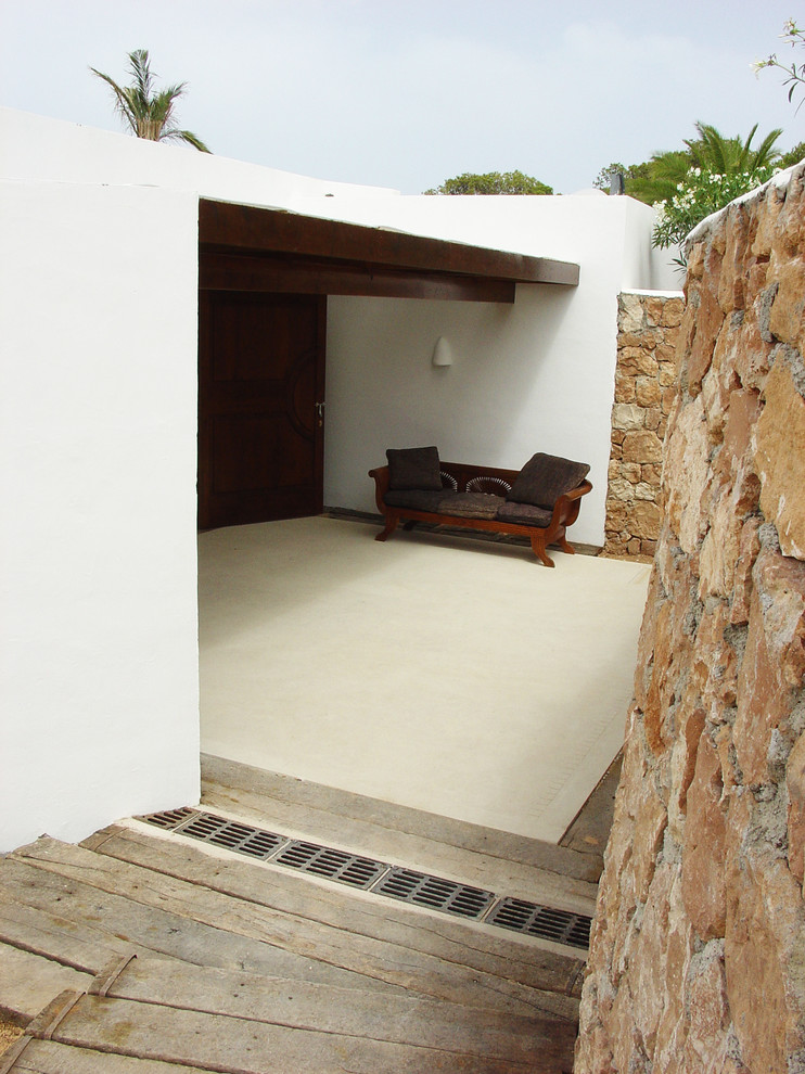 Imagen de patio mediterráneo de tamaño medio en patio trasero con losas de hormigón