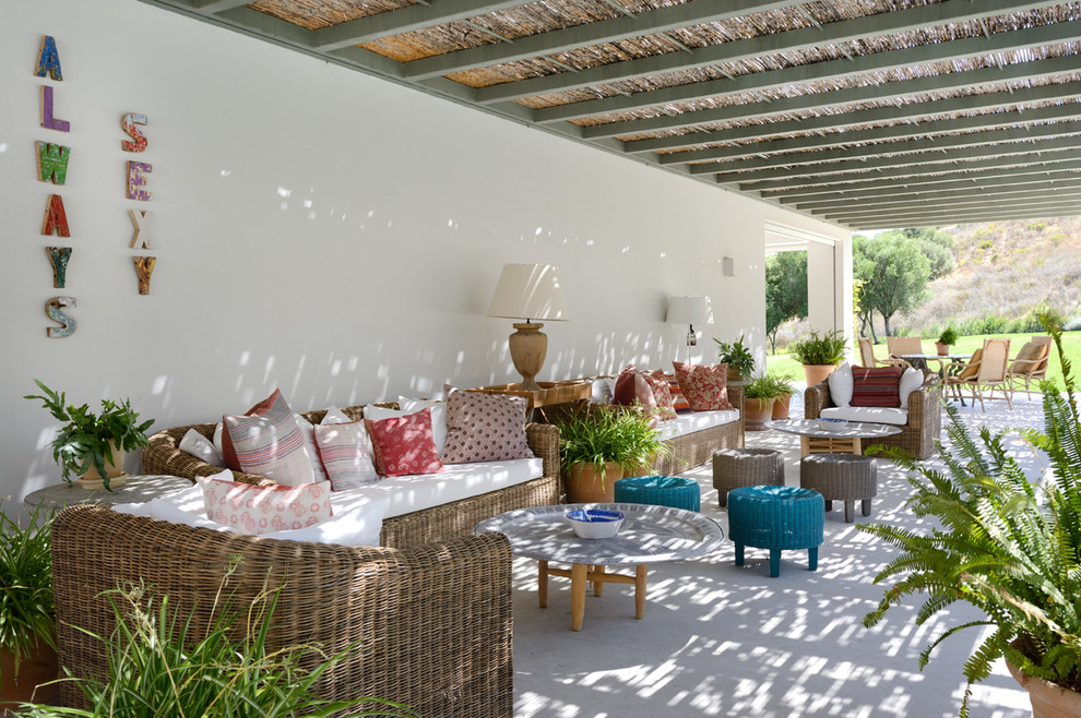 Large tuscan backyard patio photo in Seville with a pergola